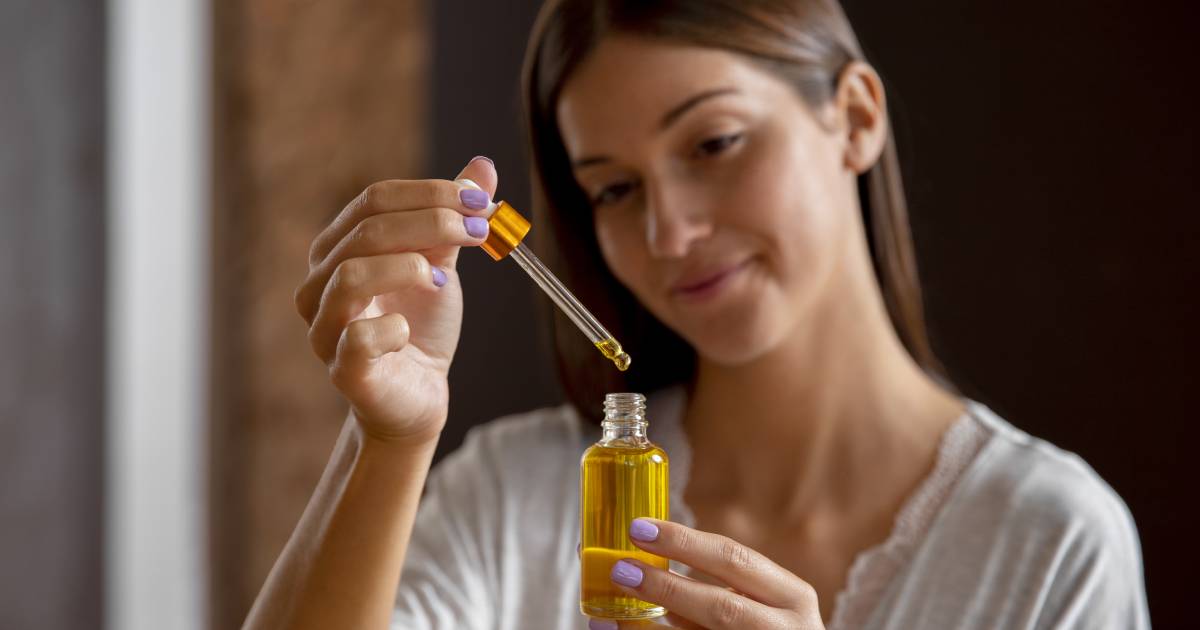 Woman applying hair oil to her hair